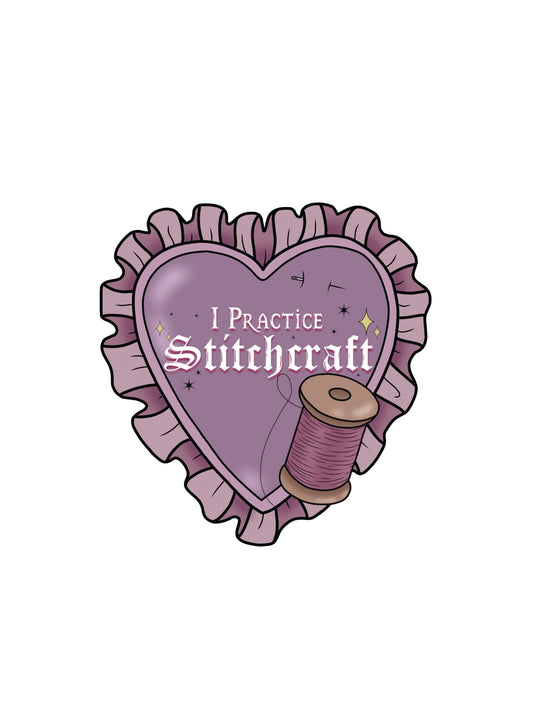 A mauve badge in the shape of a love heart, with a ruffle around the outside. Inside the badge it says "I Practice Stitchcraft" with stars sprinkled around. beneath the text there is a spool of purple thread. Above the test there is a needle stuck through the fabric of the badge